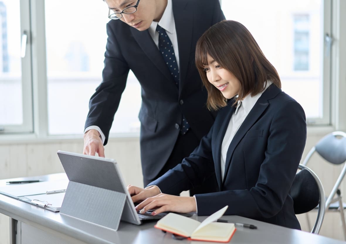 パソコンで指示を受けながらキーボードを打ち込んでいる女性