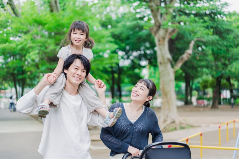 肩車をしてもらっている女の子と夫婦