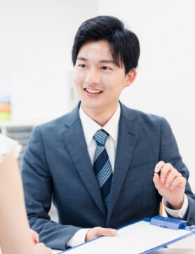 向かい合っている人に話しかけるスーツ姿の男性